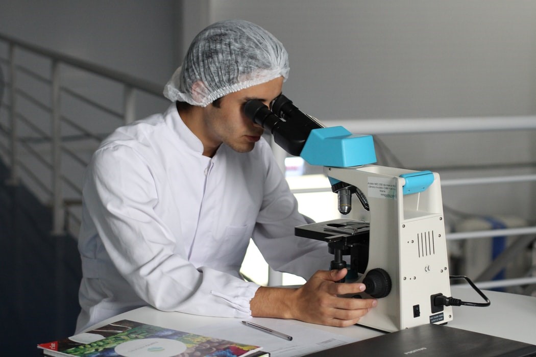 Un scientifique en train de faire des recherches au microscope