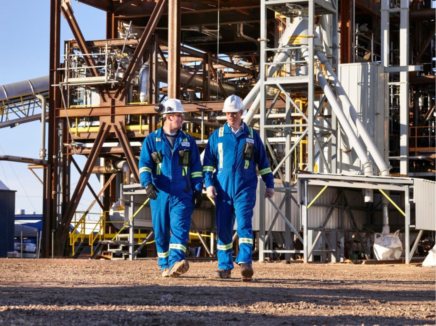 Deux ouvriers marchant ensemble à la sortie d'une usine